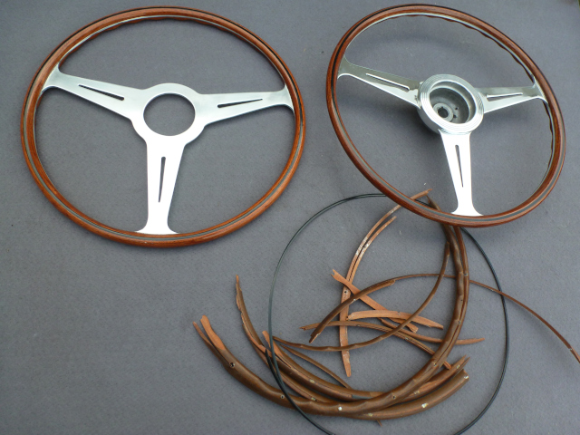 The restored steering wheel next to a newly made copy and the remains of the original wood