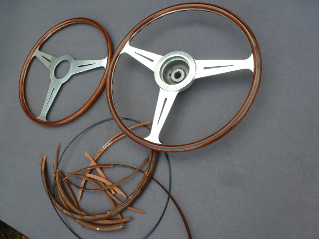 The restored steering wheel next to a newly made copy and the remains of the original wood