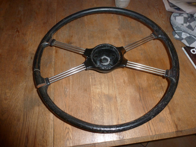 Steering wheel before restoration. During restoration, the black hub will be painted and the spokes polished